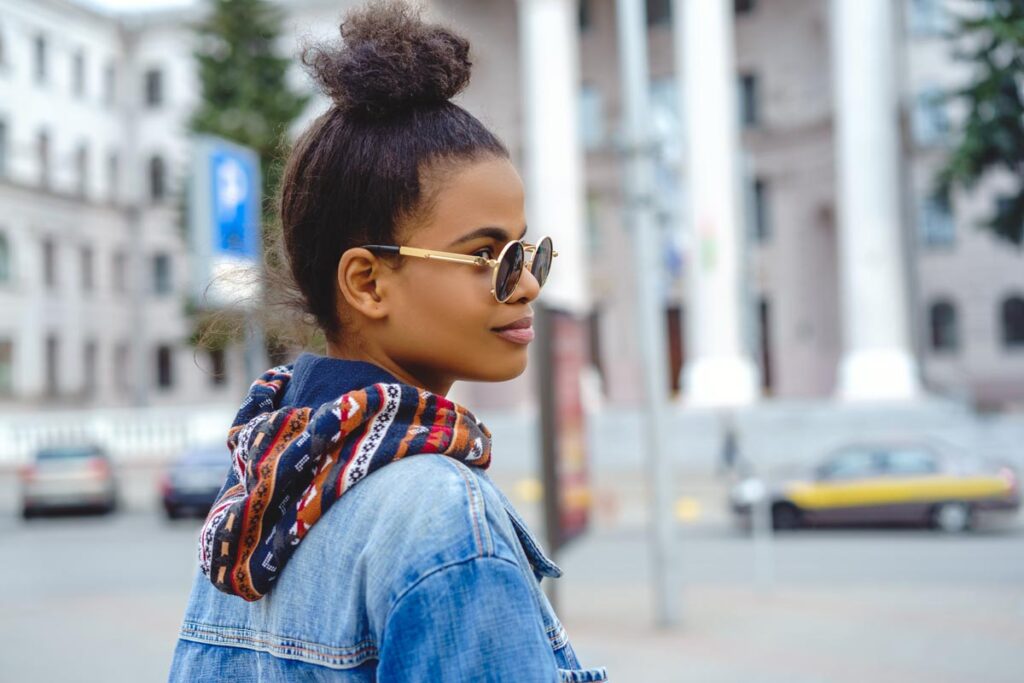 Stylish african american girl wearing sunglasses on city street