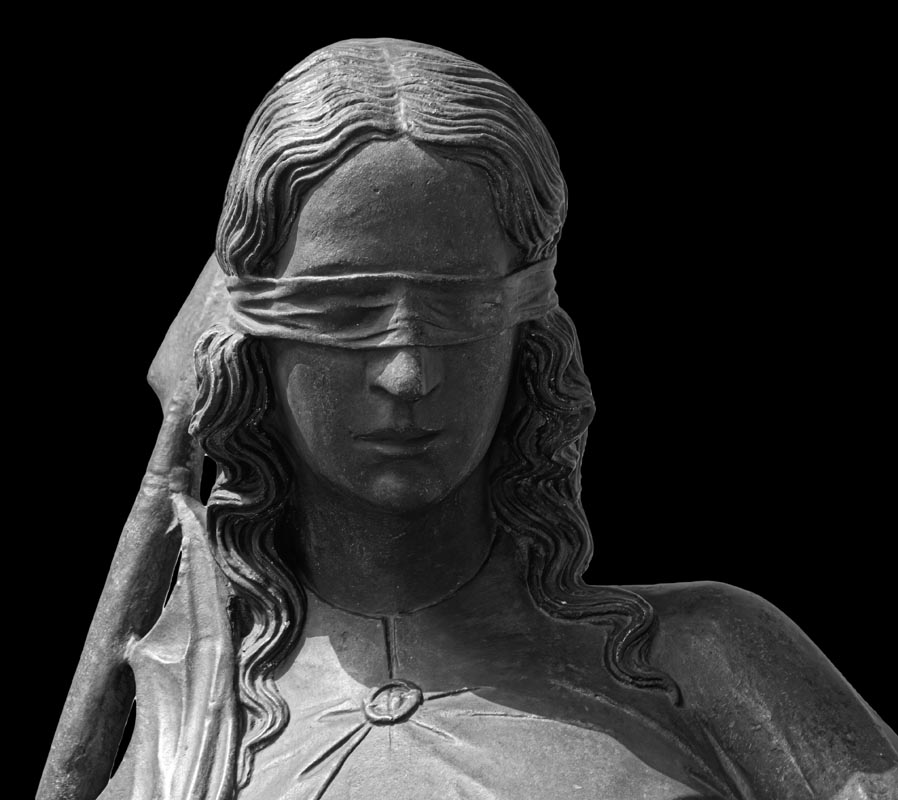 Lady justice or Themis Symbol of justice isolated on black background. Close-up of lady justice statue with blindfold.