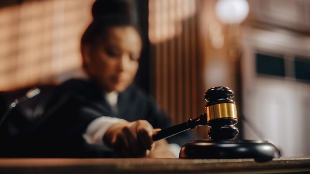 Court of Law Trial in Session: Honorable Female Judge Pronouncing Sentence, striking Gavel. Focus on Gavel, Cinematic Shot of Dramatic Verdict. Close-up Shot.